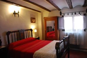 特鲁埃尔丰达托萨尔旅馆的一间卧室配有一张带红色毯子的床