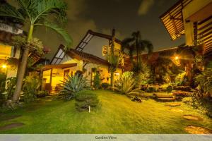 日惹都塔宾馆的一座房子,晚上有棕榈树庭院