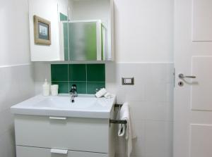 阿特拉尼弗罗拉旅馆的白色的浴室设有水槽和镜子