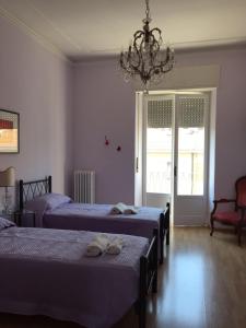 安科纳Affittacamere del viaggiatore的一间卧室配有两张床和吊灯。