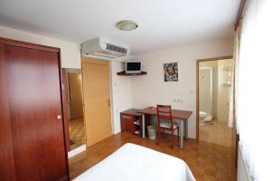 卢布尔雅那克梅茨基赫拉姆旅馆的客房设有一张床、一张桌子和一张桌子。