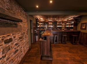 Bowmore路荷喜德酒店的一间设有石墙的酒吧和一间带凳子的酒吧