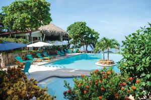 El NísperoParaiso Escondido Hotel Villas & Resort的度假村的游泳池,配有椅子和遮阳伞