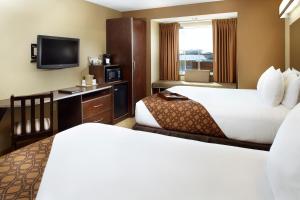 TriadelphiaMicrotel Inn & Suites by Wyndham Wheeling at The Highlands的酒店客房设有两张床和一台平面电视。