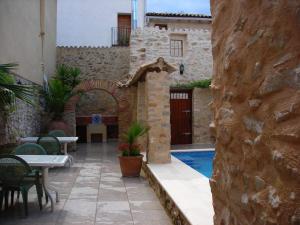 Patró卡萨萨斯特塞吉酒店的庭院设有游泳池、桌子和椅子。
