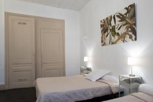 里昂法库尔德酒店的一间卧室设有两张床,墙上挂着一幅画