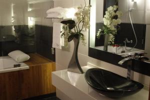 朱尼耶卢克索酒店 的浴室设有黑色水槽和花瓶