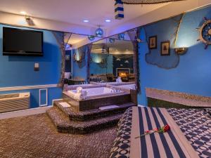本赛霖姆Inn of The Dove Romantic Luxury & Business Suites的一间客房设有浴缸和电视。