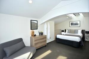 基督城Southwark Hotel & Apartments的一间卧室配有一张床和一张沙发