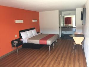 圣安东尼奥圣安东尼奥6号汽车旅馆的酒店客房的床铺拥有橙色的墙壁