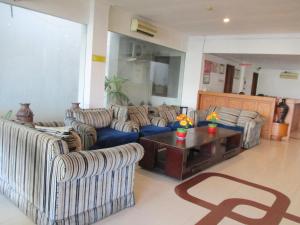 雅加达大篷车酒店的客厅配有两张沙发和一张咖啡桌
