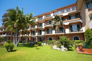 陶尔米纳卡帕莱纳酒店的一座棕榈树环绕的大建筑