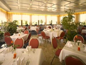 Mainhardt晓晨酒店的用餐室配有桌椅和白色的桌布