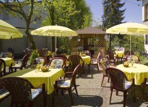 Mainhardt晓晨酒店的室外餐厅设有桌椅和遮阳伞。