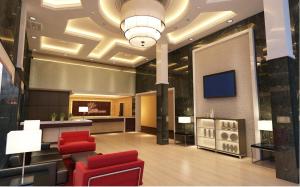 马六甲霍尔马克皇冠酒店的大堂设有红色椅子和天花板上的电视