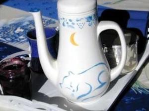 勒波诺埃库伊特酒店的托盘上一个白色花瓶,上面有猫