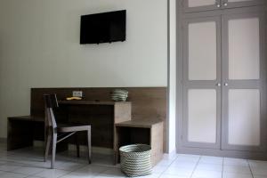 布里尤德Hôtel Poste et Champanne的一间设有一张桌子的房间,墙上有一台电视机