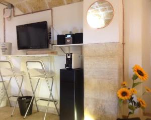 巴里Loft Piccinni nel cuore di Bari的一间配有电视和花瓶桌子的客房