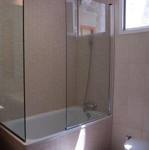 塞维利亚戈雅酒店的带浴缸和玻璃淋浴间的浴室。