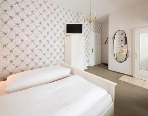 兰河畔马尔堡Hotel Haus Müller的卧室配有白色的床和镜子