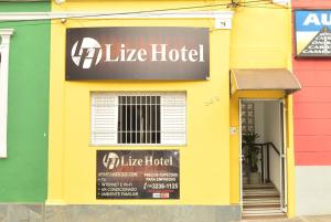 坎皮纳斯Lize Hotel Rodoviária的黄色建筑,上面有酒店标志