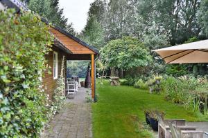 VeendamB&B Houtstee的花园设有一座带庭院的小房子