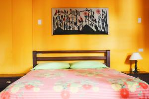 巴尼奥斯Hostal Timara的卧室配有一张床,墙上挂有绘画作品