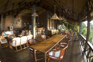 美娜多Lumbalumba Resort - Manado的用餐室配有大型木桌和椅子