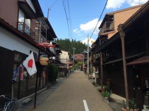 高山Takayama Ninja House的建筑物上一条有旗帜的空街道