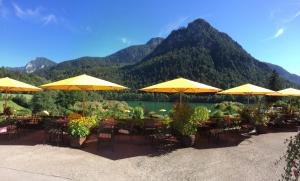 巴特莱辛哈尔胡波特斯膳食公寓酒店的湖前的一组黄伞桌子