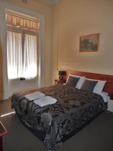 格伦因尼斯格兰德中央酒店的一间卧室设有一张大床和一个窗户。