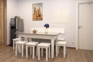 圣地亚哥－德孔波斯特拉Albergue Linares的厨房配有桌椅和冰箱。
