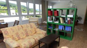 蒙多涅多El Albergue del Montero的客厅配有沙发和带书籍的书架