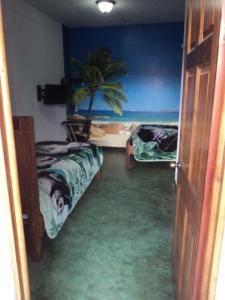 Miramar卡比纳斯朵迷培奈酒店的一间设有两张床的房间,里面有一棵棕榈树