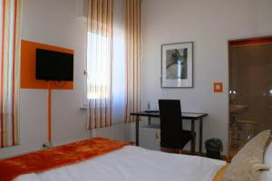 新伊森堡新伊森堡卡萨酒店的酒店客房配有一张床、一张书桌和一台电视。