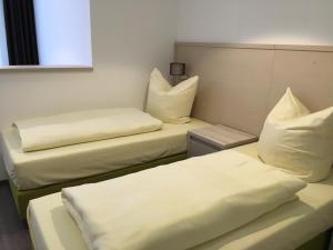贝恩堡弗斯特耐克酒店的配有2张床的带白色床单和枕头的客房