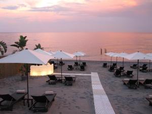 陶尔米纳卡帕莱纳酒店的海滩上的一组椅子和遮阳伞
