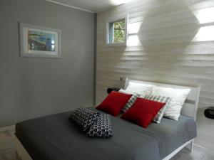 Saint-Laurent-de-la-PréeLa Désirade的一间卧室配有红色和白色枕头的床