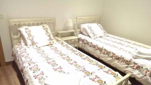 PereñaCasa Rural El Zumaque的两张睡床彼此相邻,位于一个房间里