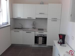 卡尼洛瑞维拉Ca du Chicco的厨房配有白色橱柜和水槽
