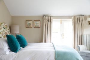 亨格福德普赛特旅馆的一间卧室配有一张带蓝色枕头的床和一扇窗户。