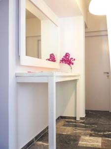 马蒂Flower Garden的浴室配有带镜子的白色梳妆台