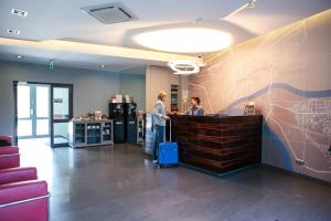 马佐夫舍地区新庄园莫德林机场索克沃弗斯卡酒店的两个人站在办公室柜台