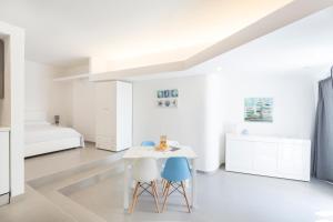 拉古萨码头Marina Loft Sicily的白色的客房配有2把椅子、桌子和1张床