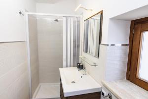 杰拉切La Casetta的白色的浴室设有水槽和淋浴。