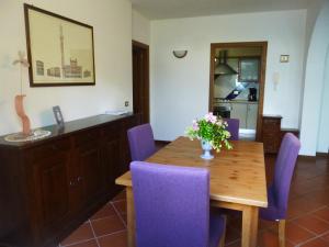 穆尔洛Villa Righino的一间带木桌和紫色椅子的用餐室