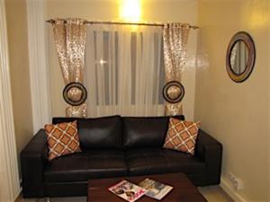 科洛里加巴里公寓的客厅配有黑色真皮沙发和桌子