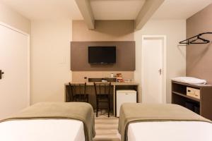 弗洛里亚诺波利斯法洛尔达伊拉酒店的客房设有两张床、一张桌子和一台电视机。
