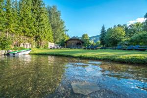 魏森湖Das Leonhard - Naturparkhotel am Weissensee的河上的小船,船底有船舱