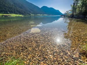 魏森湖Das Leonhard - Naturparkhotel am Weissensee的一大片水体,背景是群山